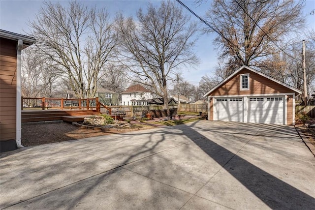 view of yard featuring a garage, an outbuilding, fence, and a deck