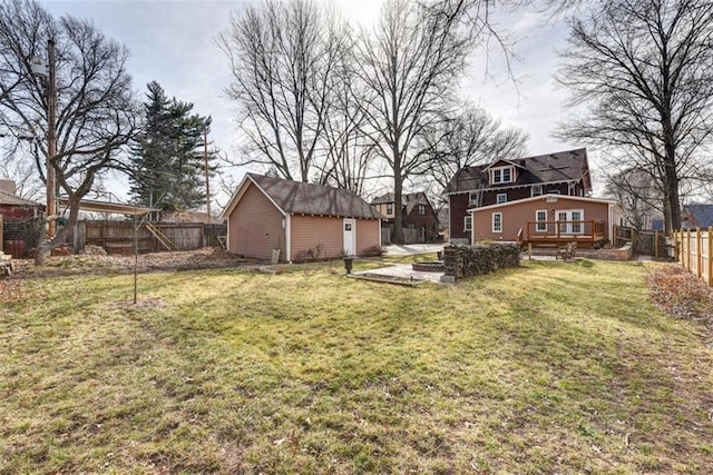 view of yard with a fenced backyard, an outdoor structure, and a wooden deck