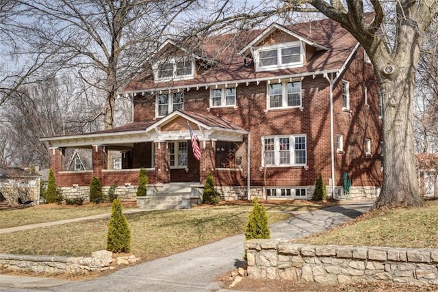 view of front of property featuring brick siding and a front yard