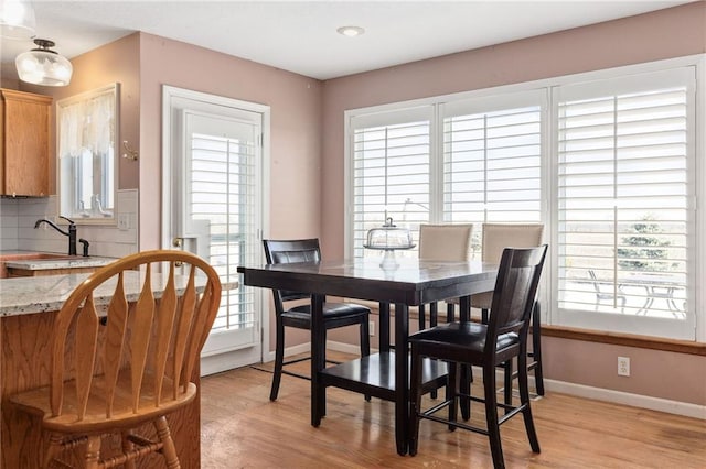 dining area featuring baseboards and light wood-style floors