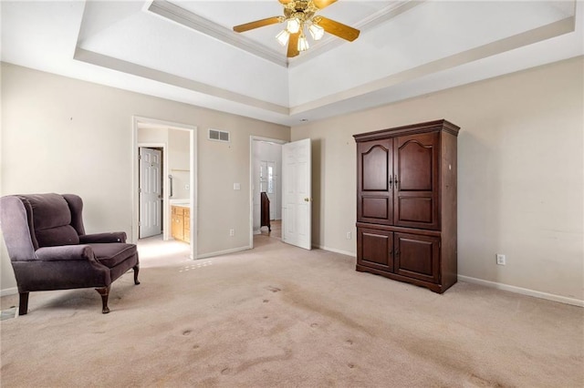 living area with visible vents, baseboards, ceiling fan, light colored carpet, and a tray ceiling