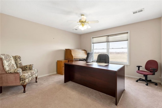 office featuring visible vents, light colored carpet, baseboards, and ceiling fan