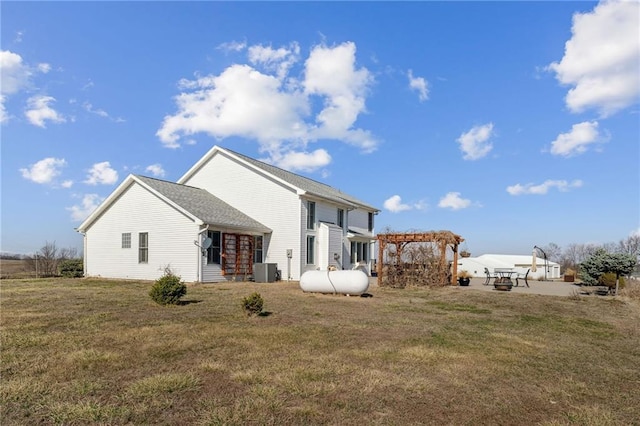 back of property featuring central air condition unit, a pergola, and a yard