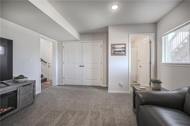 living area featuring stairs, carpet, and baseboards