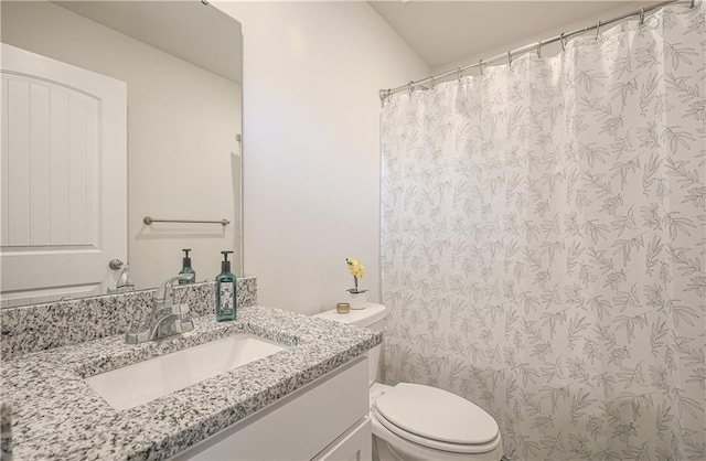 bathroom with curtained shower, toilet, and vanity