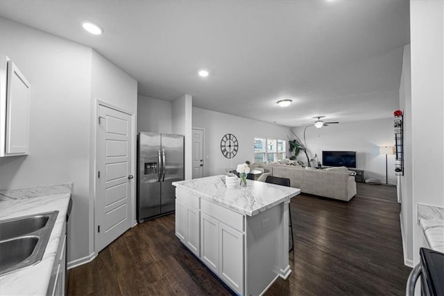 kitchen with white cabinets, ceiling fan, a kitchen island, dark wood-style flooring, and stainless steel refrigerator with ice dispenser