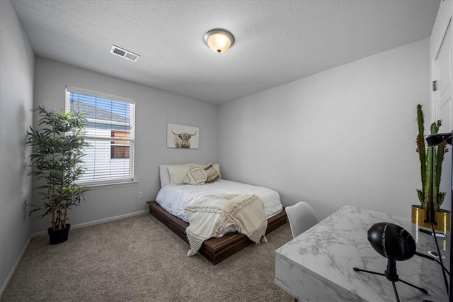 carpeted bedroom with a textured ceiling, visible vents, and baseboards