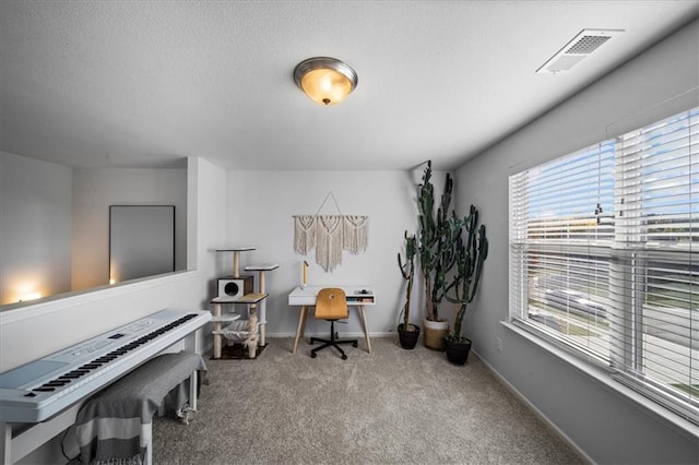 carpeted home office featuring a textured ceiling, visible vents, and baseboards