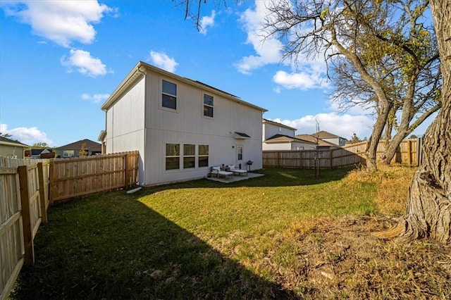 rear view of property featuring a patio area, a fenced backyard, and a lawn