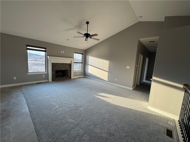 unfurnished living room featuring baseboards, visible vents, vaulted ceiling, carpet floors, and a high end fireplace