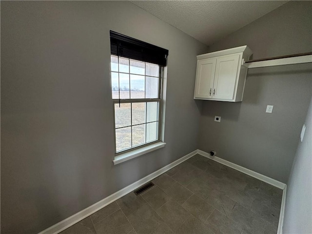 laundry area featuring a textured ceiling, visible vents, baseboards, cabinet space, and electric dryer hookup