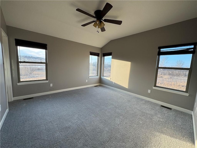 unfurnished room with lofted ceiling, carpet floors, baseboards, and visible vents