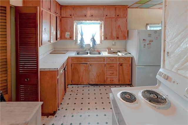 kitchen with light floors, white appliances, light countertops, and a sink