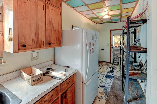 kitchen featuring brown cabinets, light countertops, and freestanding refrigerator