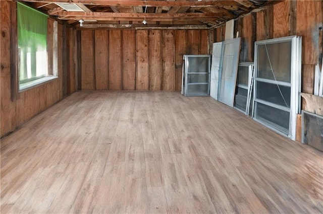 empty room featuring wooden walls and light wood-style floors