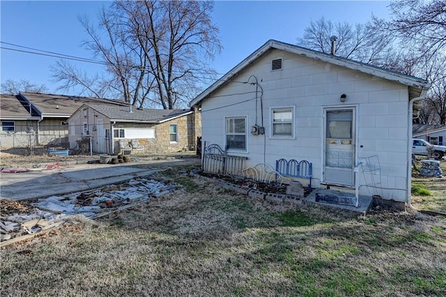 back of property featuring a yard and fence