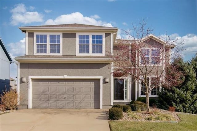 view of front facade with stucco siding, an attached garage, and concrete driveway