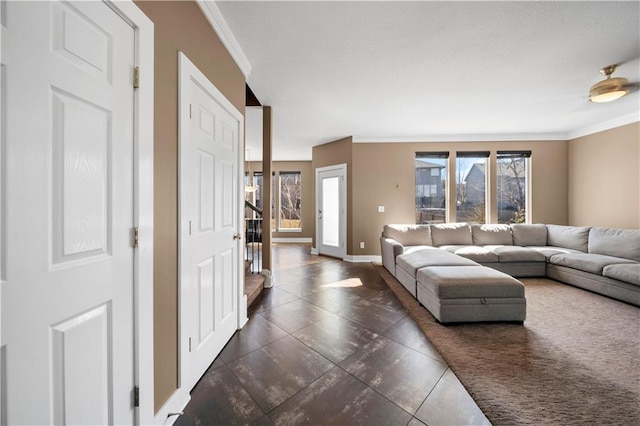 living room with a healthy amount of sunlight, baseboards, and ornamental molding