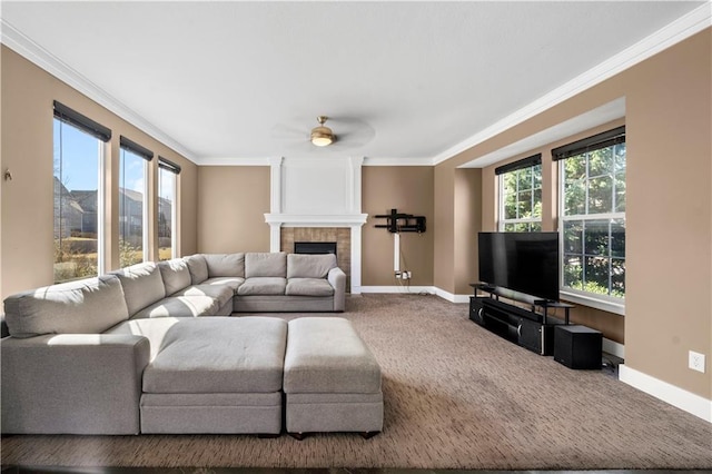 carpeted living area featuring a tiled fireplace, plenty of natural light, baseboards, and ornamental molding