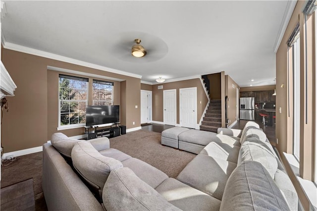 living area featuring stairway, crown molding, baseboards, and dark colored carpet