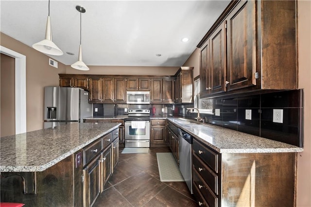 kitchen featuring visible vents, a sink, tasteful backsplash, stainless steel appliances, and dark brown cabinets