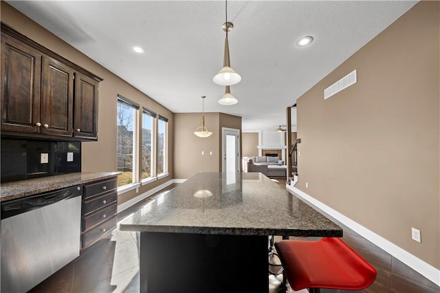 kitchen with baseboards, visible vents, dark brown cabinets, dishwasher, and decorative light fixtures