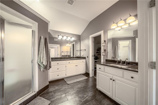 bathroom featuring lofted ceiling, two vanities, a shower stall, and a sink