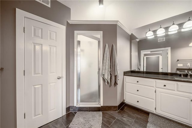 bathroom featuring visible vents, baseboards, a shower with shower door, tile patterned floors, and vanity