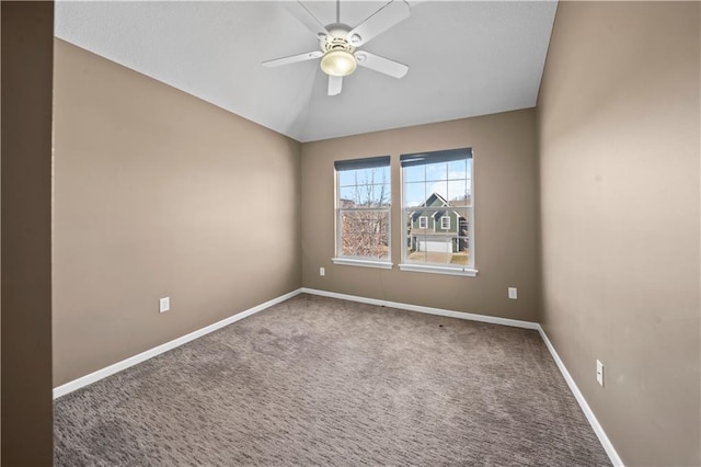 unfurnished room with vaulted ceiling, carpet flooring, a ceiling fan, and baseboards