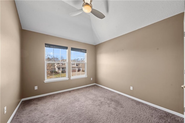 empty room featuring baseboards, lofted ceiling, carpet floors, and a ceiling fan