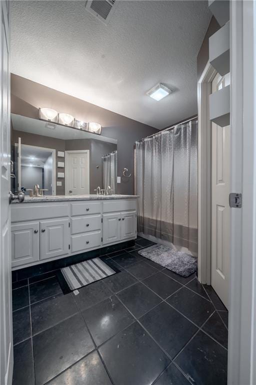 full bathroom with visible vents, a shower with curtain, a textured ceiling, tile patterned flooring, and double vanity