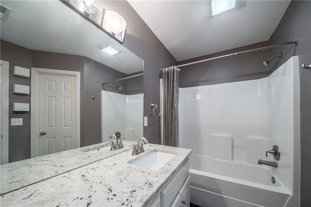 full bath featuring visible vents, vanity, a textured ceiling, and shower / tub combo