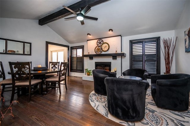 living room featuring a ceiling fan, a brick fireplace, lofted ceiling with beams, and hardwood / wood-style flooring