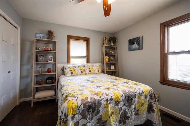 bedroom with visible vents, baseboards, dark wood finished floors, and a ceiling fan