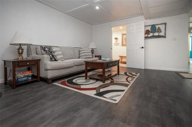 living area with baseboards, wood finished floors, and beamed ceiling