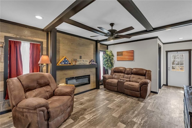 living area with a glass covered fireplace, ceiling fan, beamed ceiling, wood finished floors, and recessed lighting