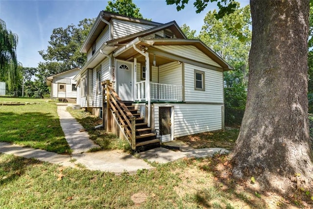 view of front of house featuring a porch, a front lawn, and stairs