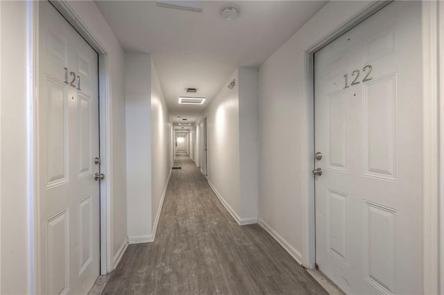 corridor featuring wood finished floors and baseboards