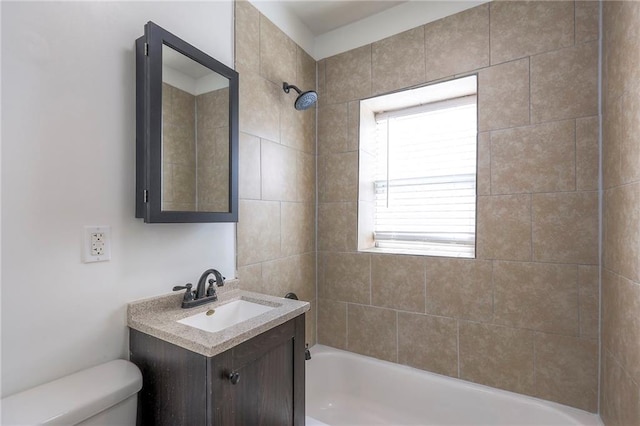 bathroom with washtub / shower combination, vanity, and toilet