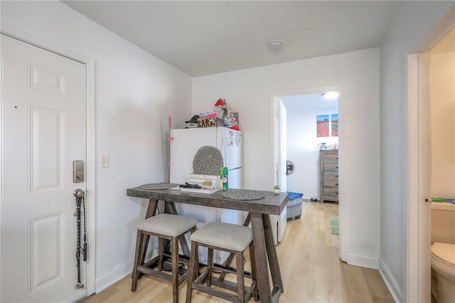 dining area featuring baseboards and light wood-style floors