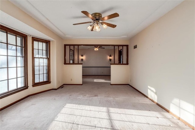 carpeted empty room featuring visible vents, ceiling fan, and baseboards