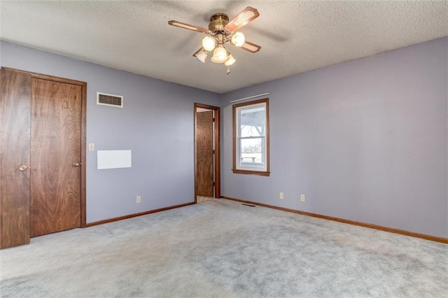 unfurnished bedroom with visible vents, baseboards, a textured ceiling, and carpet flooring