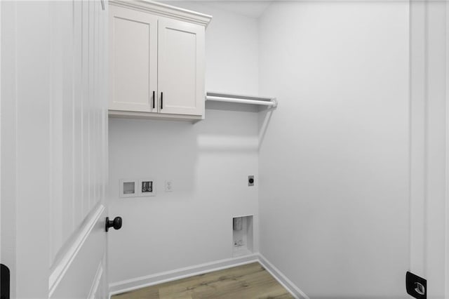 clothes washing area featuring wood finished floors, baseboards, hookup for an electric dryer, cabinet space, and washer hookup