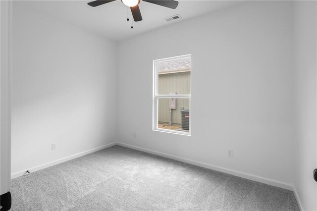 carpeted empty room featuring visible vents, baseboards, and a ceiling fan