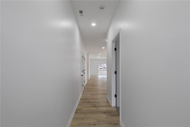 corridor featuring recessed lighting, light wood-style floors, and baseboards