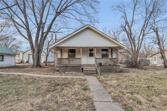 bungalow with a garage, covered porch, and an outdoor structure