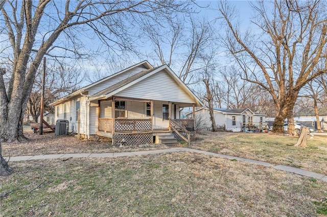 bungalow with central air condition unit, covered porch, and a front yard