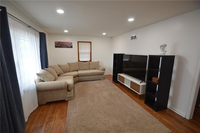 living area with baseboards, wood finished floors, visible vents, and recessed lighting