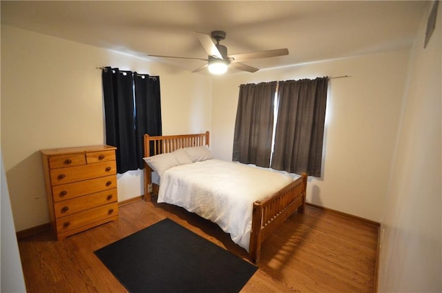 bedroom with ceiling fan, baseboards, and wood finished floors