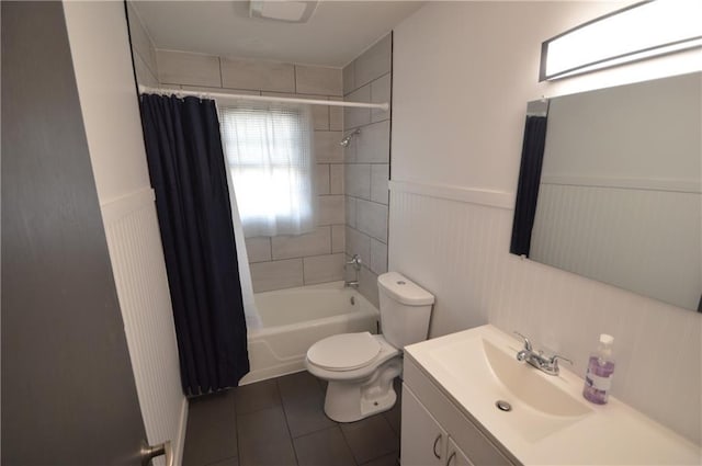 bathroom with a wainscoted wall, toilet, shower / bath combo, vanity, and tile patterned floors